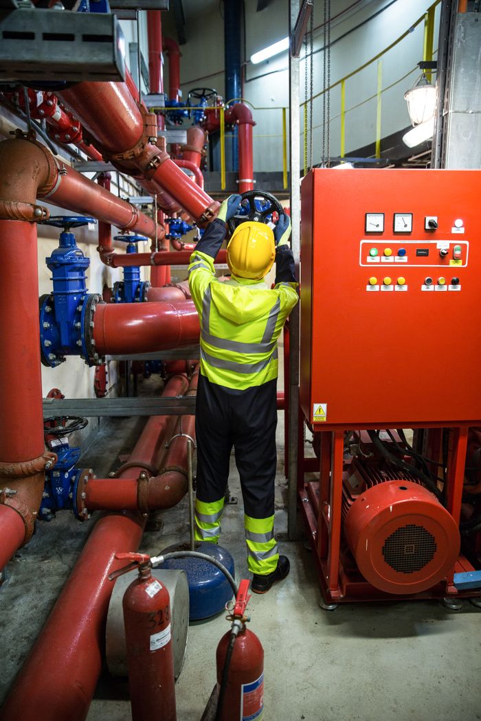 Services Worker in uniform operates machinery in industrial setting, emphasizing safety and productivity.