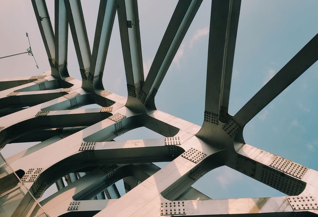 Mastering the First Impression: Your intriguing post title goes here Abstract view of a modern bridge with intricate steel beams and blue sky backdrop.